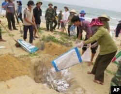 FILE - Villagers bury dead fish on a beach in Quang Binh, Vietnam, April 28, 2016. Vietnam's government found Taiwan's Formosa Ha Tinh Steel Corp responsible for a toxic wastewater spill causing massive economic and environmental damage.