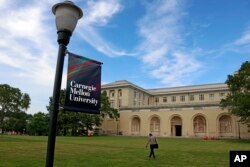 Seseorang berjalan melewati Gedung Sekolah Tinggi Seni Rupa di kampus Universitas Carnegie Mellon di Pittsburgh Jumat, 7 Juni 2019. (Foto: AP/Gene J. Puskar)