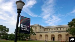 Seseorang berjalan melewati Gedung Sekolah Tinggi Seni Rupa di kampus Universitas Carnegie Mellon di Pittsburgh, Jumat, 7 Juni 2019. (Foto: AP / Gene J. Puskar)