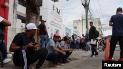 Migrants, mostly Venezuelans, wait outside Mexico's National Migration Institute to request repatriation flights after the cancellation of U.S. Customs and Border Protection CBP One appointments, in Tuxtla Gutierrez, Mexico, Feb. 20, 2025. 