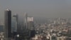 Vista general de edificios y casas en medio de la contaminación en la Ciudad de México, México, 6 de diciembre de 2024. Fotografía tomada a través de una ventana de vidrio de un edificio. 