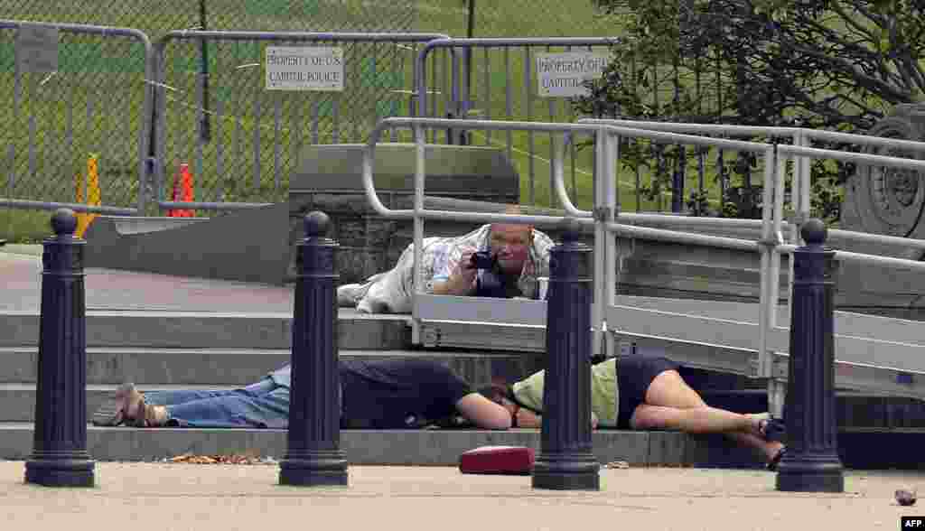 People take cover as gun shots were being heard at the U.S. Capitol in Washington.