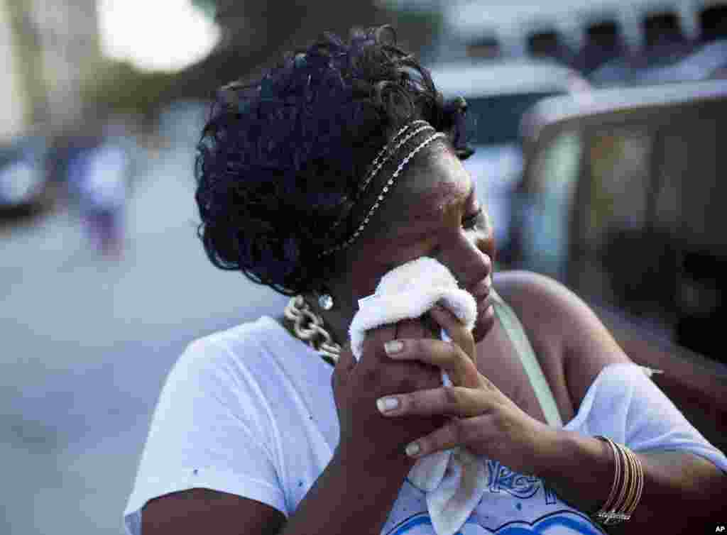 Aurelia Washington cries as she talks about her grandmother Ethel Lance who died in Wednesday's shooting, as she leaves a sidewalk memorial in front of Emanuel AME Church, June 18, 2015, in Charleston, S.C. 