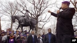 FILE - The Rev. Jesse Jackson gestures toward a statue of Confederate Gen. Robert E. Lee during a rally.