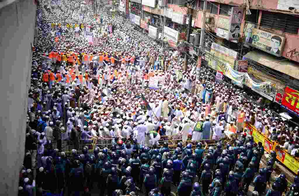 Supporters of Islami Andolan Bangladesh, an Islamist political party, face policemen during a protest against French President Emmanuel Macron and against the publishing of caricatures of the Prophet Muhammad, in Dhaka, Bangladesh.