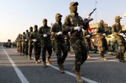 FILE - Members of Iraqi Popular Mobilization Forces take part in a military parade in the town of Taza, south of the northern oil city of Kirkuk, Iraq, June 28, 2019.