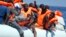 FILE - Migrants wearing life vests float in an inflatable boat during a rescue operation from the Aquarius vessel of SOS Mediterranee NGO and MSF (Doctors Without Borders) in the sea some 25 Nautical miles (29 miles, 46 kilometers) north of the Libyan coast, Aug. 27, 2017.