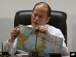 Philippine President Benigno Aquino III looks at a Philippine map as he meets with officials of the National Disaster Risk Reduction & Management Council in preparation for Typhoon Hagupit in suburban Quezon city, north of Manila, Philippines Thursday, De