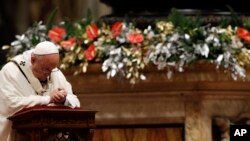 Pope Francis kneels as he celebrates the Christmas Eve Mass in St. Peter's Basilica at the Vatican, Dec. 24, 2015.
