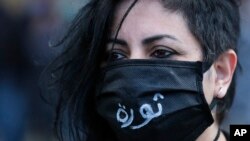 An anti-government protester wearing a mask to help curb the spread of the coronavirus with Arabic that reads, "Revolution," attends a protest against the deepening financial crisis, in Beirut, Lebanon, Monday, April 27, 2020. Photo: AP