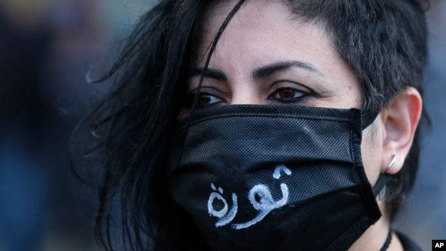 An anti-government protester wearing a mask to help curb the spread of the coronavirus with Arabic that reads, "Revolution," attends a protest against the deepening financial crisis, in Beirut, Lebanon, Monday, April 27, 2020. Photo: AP