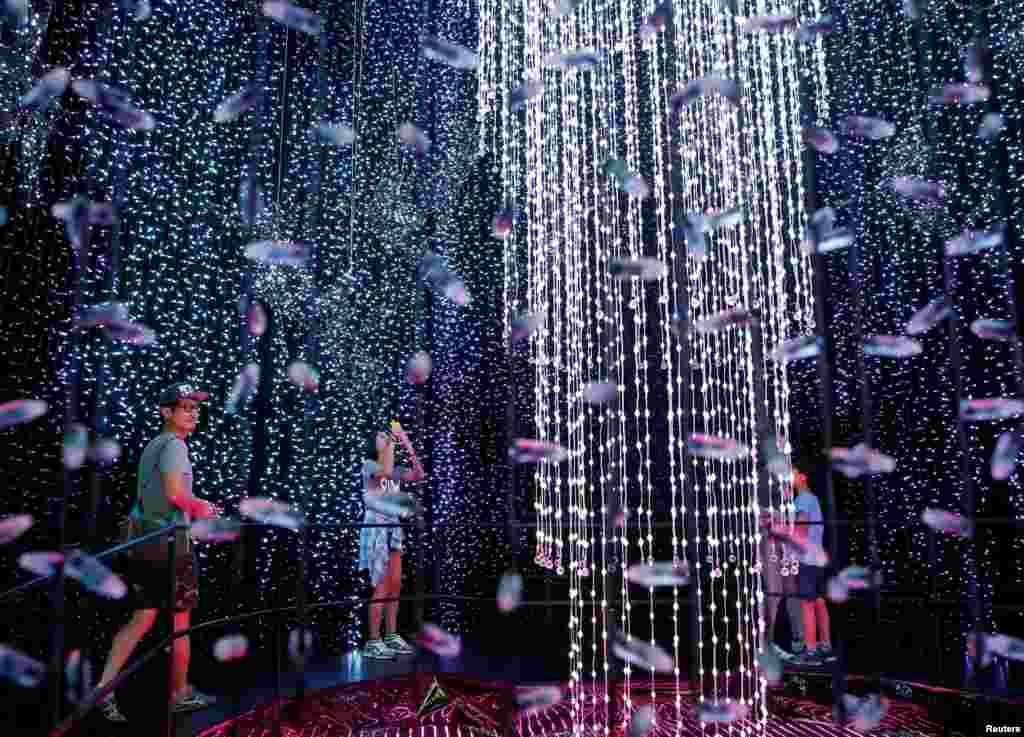 Pengunjung menikmati atraksi Natal berupa cahaya 800.000 bola lampu di Universal Studios Singapura.