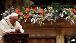 Pope Francis kneels as he celebrates the Christmas Eve Mass in St. Peter's Basilica at the Vatican, Dec. 24, 2015.