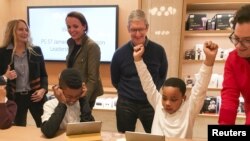 Apple Chief Executive Officer Tim Cook (C) attends an event for students to learn to write computer code at the Apple store in the Manhattan borough of New York December 9, 2015. 