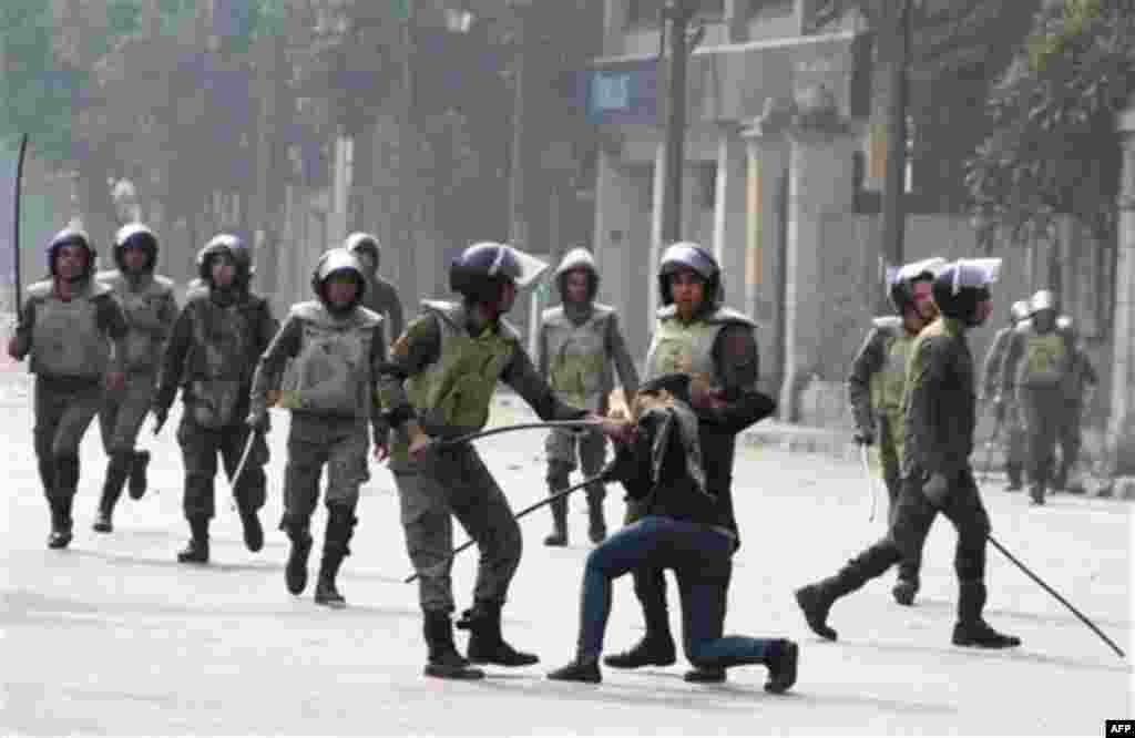 Egyptian army soldiers arrest a woman protester during clashes with military police near Cairo's downtown Tahrir Square, Egypt Friday, Dec. 16, 2011. Activists say the clashes began after soldiers severely beat a young man who was part of a sit-in outsid