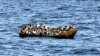 Des migrants d'origine africaine tentant de fuir vers l'Europe à bord d'un petit bateau, en mer entre la Tunisie et l'Italie, le 10 août 2023. (Photo FETHI BELAID / AFP)