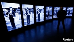 A visitor looks at screens showing Charlie Chaplin during a media tour of 'Chaplin's World', an interactive museum celebrating the life and works of the comic actor, in Corsier-sur-Vevey, Switzerland, April 16, 2016. The museum is set on the vast estate o