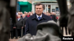 Ukraine's President Viktor Yanukovich takes part in a ceremony at the memorial complex for Soviet Ukrainian-born victims of a military conflict in Afghanistan, Kyiv, Feb. 14, 2014.
