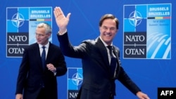 资料照片：北约秘书长斯托尔滕贝格(左)在北约布鲁塞尔总部迎接参加北约峰会的荷兰首相吕特。(2021年6月14日) 