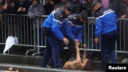 La police arrête une manifestante face au cortège du président américain Donald Trump à Paris, le 11 novembre 2018. REUTERS