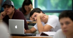 A University of Miami student studies the daily lesson plan on his computer during a Spanish language class in Coral Gables, Florida.