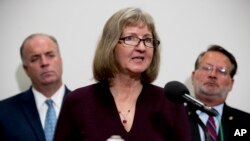 Elizabeth Whelan, the sister of Paul Whelan, accompanied by Sen. Gary Peters., D-Mich., right, and Rep. Dan Kildee, D-Mich., left, speaks at a news conference on Capitol Hill in Washington, Sept. 12, 2019, 
