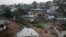 FILE - Kids jump on tires over a sewage in a slum in Freetown, Sierra Leone.