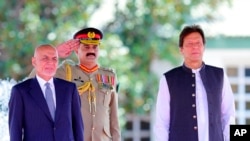 Visiting Afghan President Ashraf Ghani, left, reviews guard of honor with Prime Minister of Pakistan Imran Khan in Islamabad, Pakistan, June 27, 2019, in this photo released by the Press Information Department.