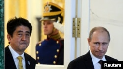 FILE - Russia's President Vladimir Putin (R) and Japan's Prime Minister Shinzo Abe are seen walking following talks at the Kremlin in Moscow April 29, 2013.