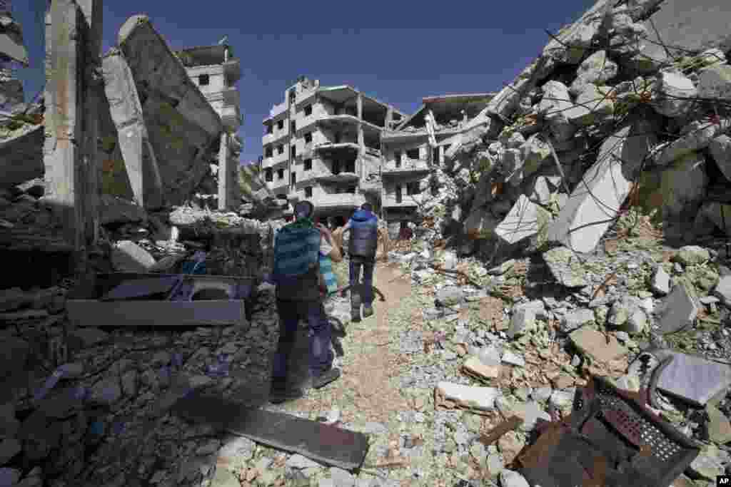 Syrian children walk between destroyed buildings in the old city of Homs, Feb. 26, 2016.