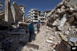 Syrian children walk between destroyed buildings in the old city of Homs, Syria, Feb. 26, 2016.