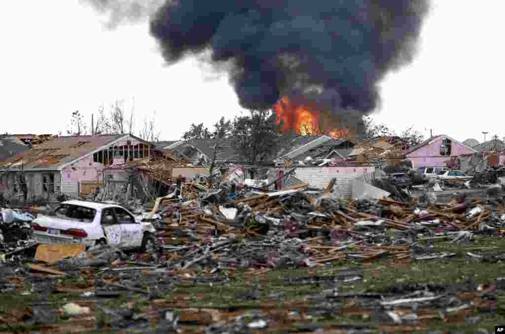 A fire burns in the Tower Plaza Addition following a tornado in Moore, Oklahoma, May 20, 2013. A tornado as much as a mile (1.6 kilometers) wide with winds up to 200 mph (320 kph) roared through the Oklahoma City suburbs Monday, flattening entire neighborhoods, setting buildings on fire and landing a direct blow on an elementary school.