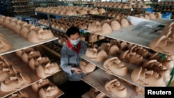 A worker checks a mask of U.S. Republican presidential candidate Donald Trump at Jinhua Partytime Latex Art and Crafts Factory in Jinhua, Zhejiang Province, China, May 25, 2016. (Reuters/Aly Song)