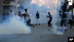 بھارتی کشمیر میں سیکیورٹی اہل کار مظاہرین کو منتشر کرنے کے لیے آنسو گیس کے گولے پھینک رہے ہیں۔ فائل فوٹو