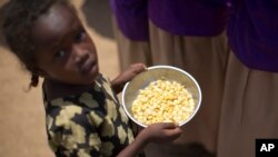 A child holds a bowl of food given out during a food distribution in the drought-affected village of Bandarero, near Moyale town on the Ethiopian border, in northern Kenya, March 3, 2017. 