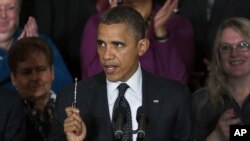 President Barack Obama holds up a pen as he speaks about the economy and the deficit in the East Room of the White House in Washington, file photo. 