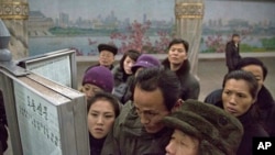 North Korean subway commuters gather around a public newspaper stand on the train platform in Pyongyang, North Korea, Dec. 13, 2013 to read the headlines about Jang Song Thaek, North Korean leader Kim Jong Un's uncle who was executed.