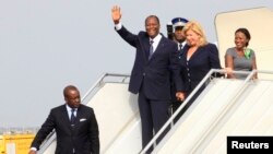 Ivory Coast's President Alassane Ouattara (L) waves next to wife Dominique (R) as they arrive at Felix Houphouet-Boigny international airport in Abidjan March 2, 2014. 