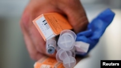 FILE - A Cataldo Ambulance medic holds used doses of naloxone after medics revived a man in his 40's who was found unresponsive from an opioid overdose in the Boston suburb of Salem, Massachusetts, Aug. 9, 2017.