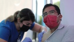 FILE - Jose Espinoza, 27, receives a vaccine against the coronavirus disease at a COVID-19 vaccination clinic in Los Angeles, California, Aug. 17, 2021.