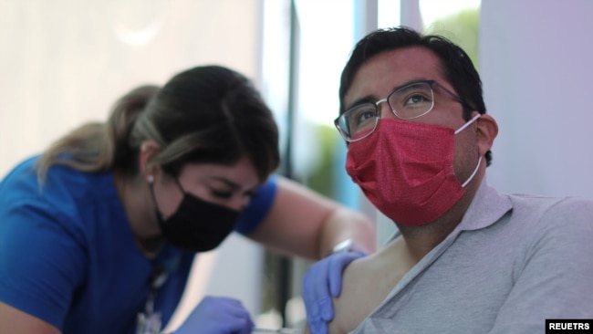 FILE - Jose Espinoza, 27, receives a vaccine against the coronavirus disease at a COVID-19 vaccination clinic in Los Angeles, California, Aug. 17, 2021.