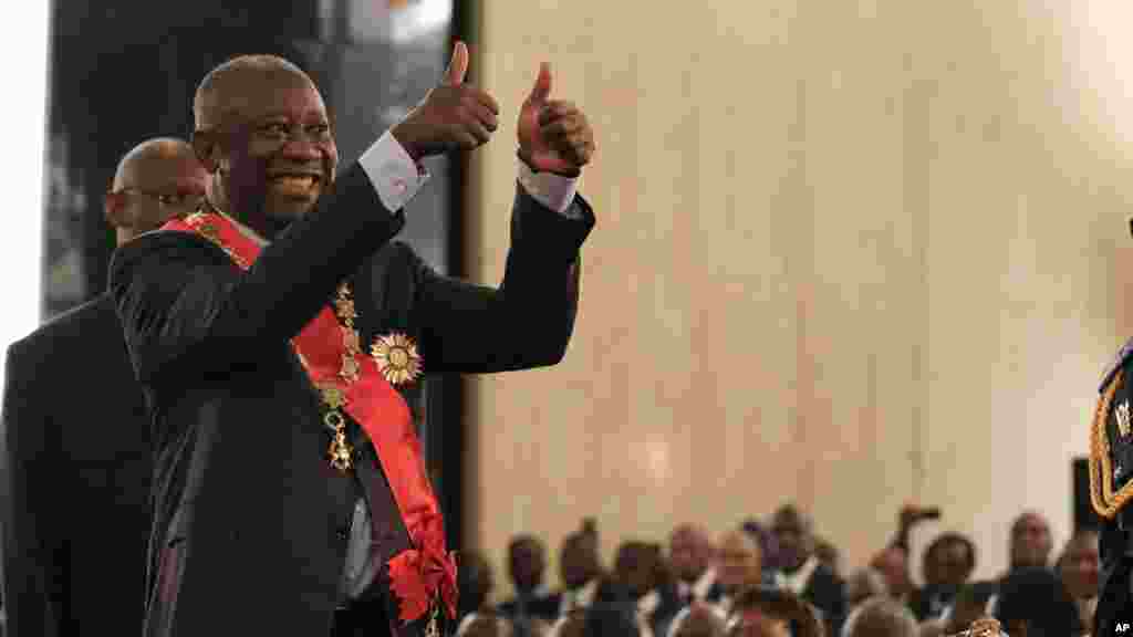 Contestant les résultats officiels de la Commission électorale qui donnent son rival Alassane Ouattarra vainqueur, le président sortant Laurent Gbagbo salue une foule de partisans et des fonctionnaires au cours de sa cérémonie de prestation de serment au Palais présidentiel d&#39;Abidjan, 4 décembre 2010.