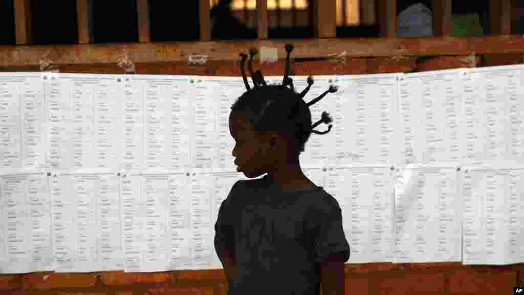 La silhouette d&rsquo;une enfant devant la liste des électeurs à un bureau de vote à Bangui, en République centrafricaine, 14 février 2016.