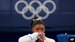 Simone Biles of the United States watches gymnasts perform at the 2020 Summer Olympics, in Tokyo. Biles says she wasn't in right "headspace" to compete and withdrew from the gymnastics team final. 