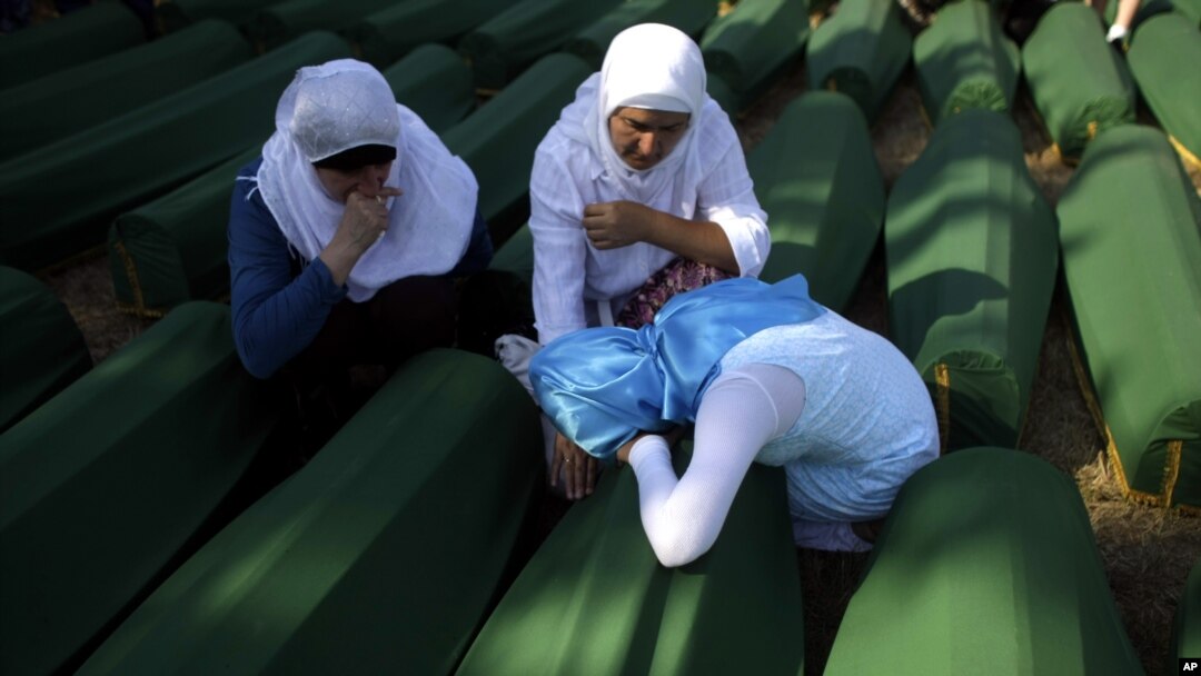 Porodice pored kovčega sa posmrtnim ostacima žrtava maskra u Srebrenici