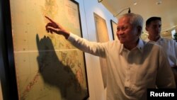 FILE - Philippine Foreign Secretary Albert Del Rosario points to an ancient map that officials said show that China's territorial claims over the South China Sea did not include the Scarborough Shoal.