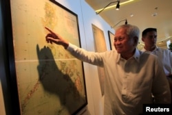 FILE - Philippine Foreign Secretary Albert Del Rosario points to an ancient map that officials said show that China's territorial claims over the South China Sea did not include the Scarborough Shoal.