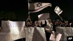 Israelis hold signs and flags as they protest the cease-fire in the southern Israeli city of Kiryat Malachi, Wednesday, Nov. 21, 2012.