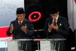 Indonesian presidential candidate Prabowo Subianto, left, with running mate Sandiaga Uno, prays prior to a televised presidential candidates debate in Jakarta, Indonesia, April 13, 2019.