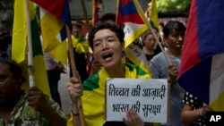 Exile Tibetans shout slogans during a protest to show support with India in the Doklam standoff in New Delhi, Aug. 11, 2017. 
